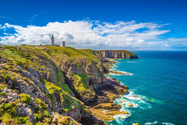 Felsige Küste mit Leuchtturm in der französischen Bretagne