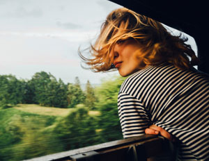 Zugreisen nach Deutschland, Frau streckt ihren Kopf aus dem Zugfenster
